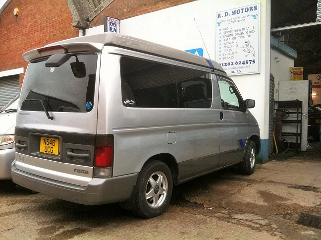 A silver Mazda Bongo in the yard at RD Motors