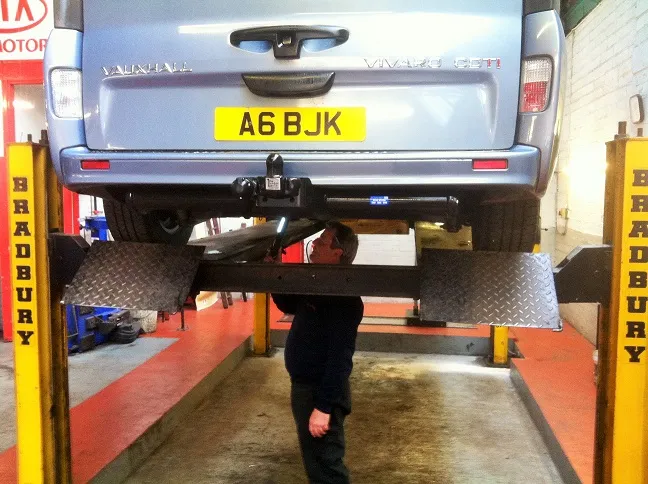 A van on the lift in the MOT bay